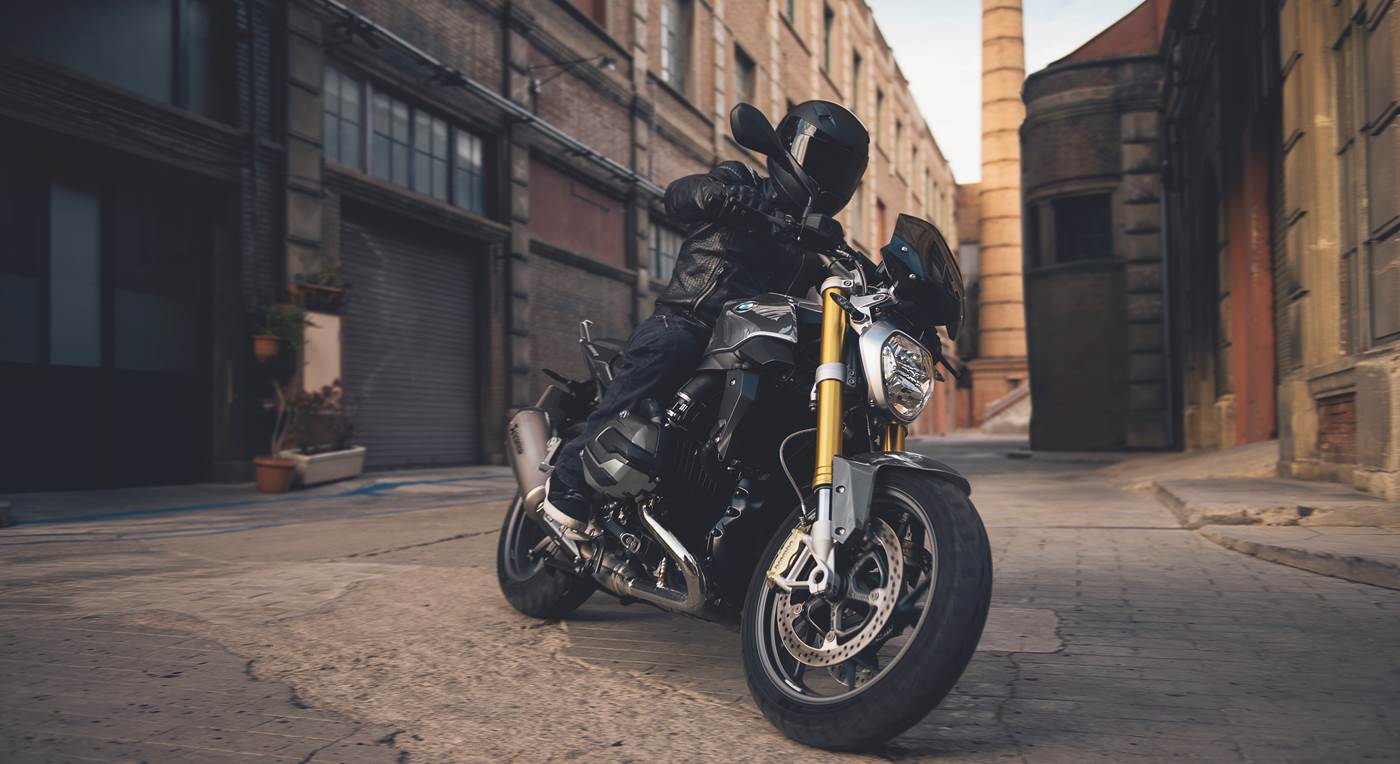 Mand på motorcykel på vej gennem industrikvarter