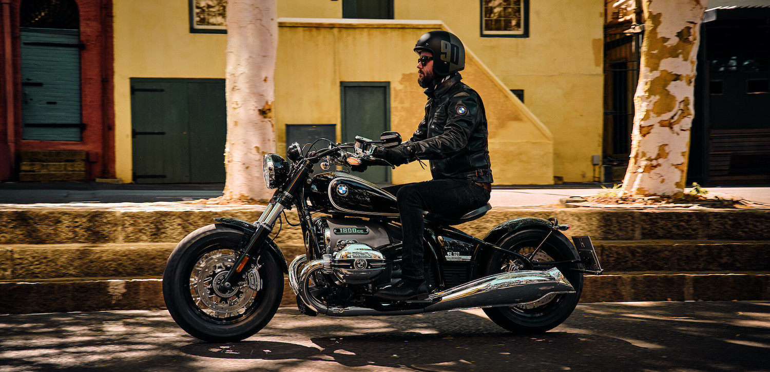 Mand i sort læderjakke kører på sort BMW R 1800 motorcykel
