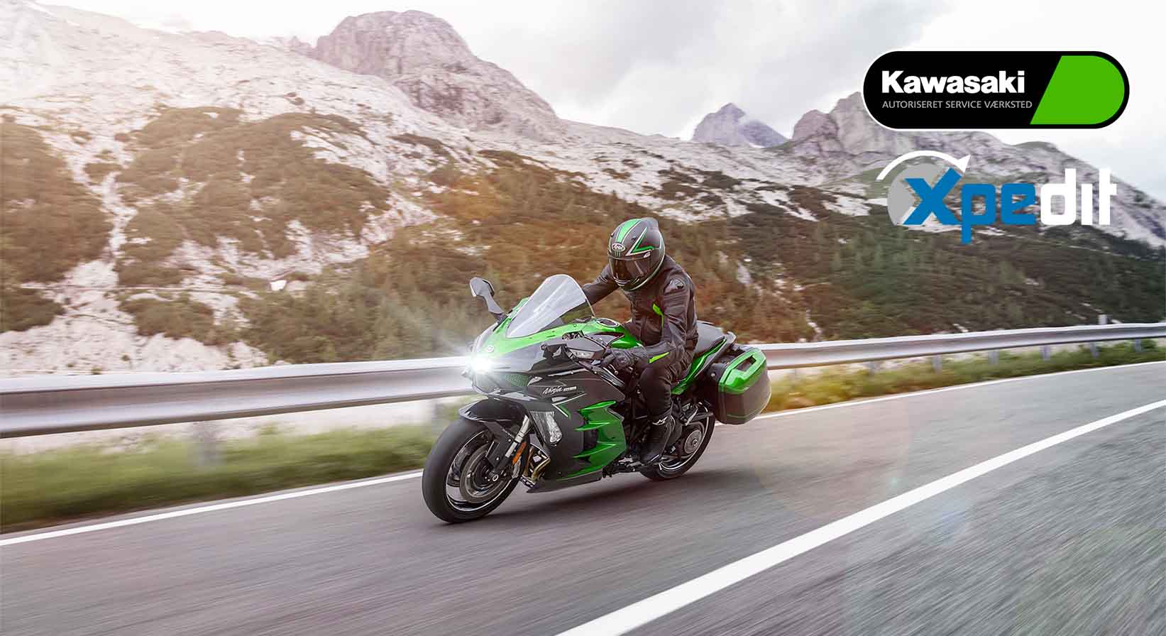 Sort og grøn Kawasaki motorcykel kører stærkt på bjergvej