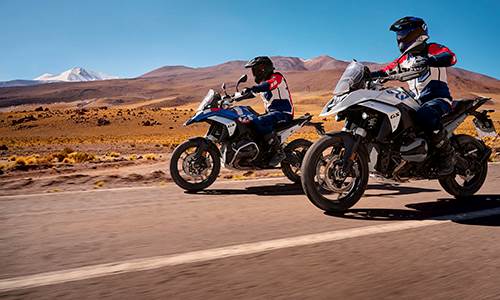 To motorcykler kører på vej i stenet bjerglandskab