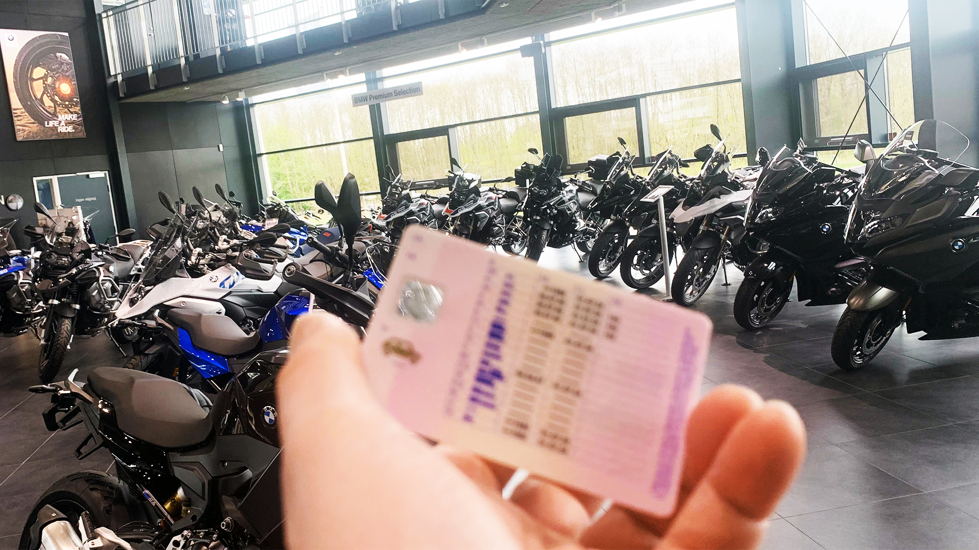 Hånd med kørekort foran motorcykeludstilling