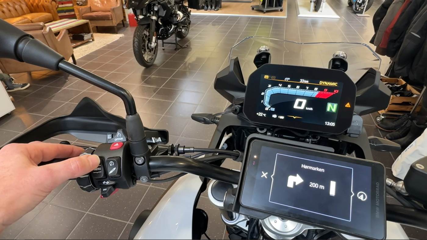 Mand sidder på BMW motorcykel og betjener menuknapper og rullehjul